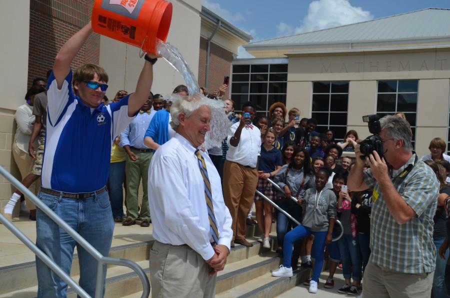 SLOW TO REACT: Principal Mike Martin is splashed with water by ELL teacher Thomas Herrington as the school watches on. 