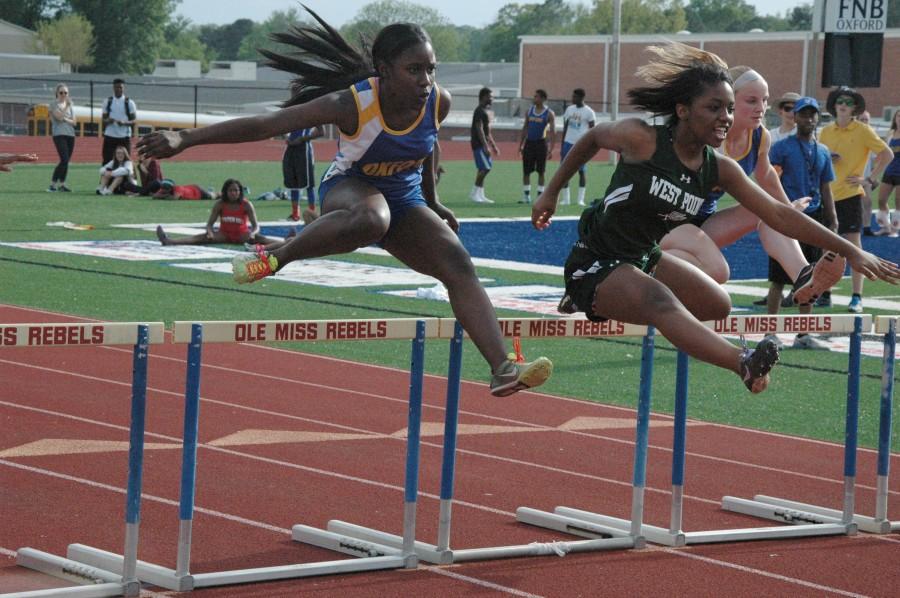Rajah Ramsey and Emily Hankins run the 100 meter hurdles. Ramsey came in 2nd place with Hayward following with 3rd.