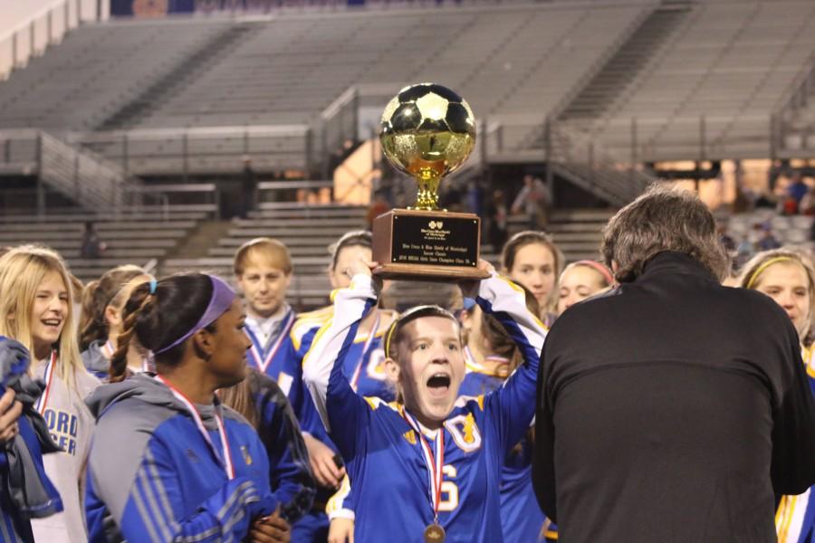 (PHOTOS BY SARIYA KHAN)

OHS senior girls soccer player Sarah Nash hoists the MHSAA Class 5A state soccer championship trophy following the Lady Chargers win against West Harrison High.