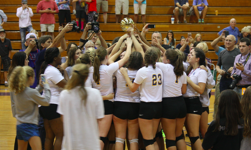 The OHS volleyball team hoists the golden ball after winning the MHSAA Class II State Championship.