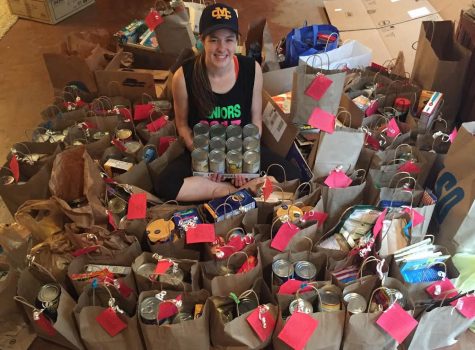 Senior Swayze Elliott sits among cans that she collected for a neighborhood food pantry drive.