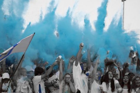 Students throw blue chalk powder to celebrate after the football team runs on the field for the Crosstown Classic against Lafayette High School. The rivalry game has been played for the past 46 years. 