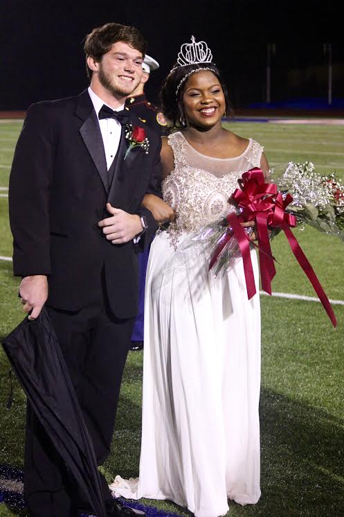 Senior Samya Clayton getting escorted by her date after being crowned homecoming queen last October.
