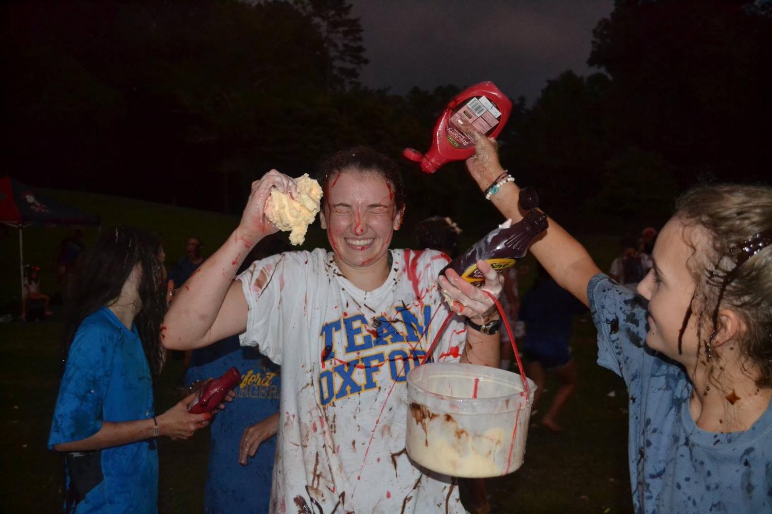 Junior Taylor Daniel squirts senior Lily Mitchell with syrup during the ice cream olympics on Aug. 17 hosted by Oxford Younglife.