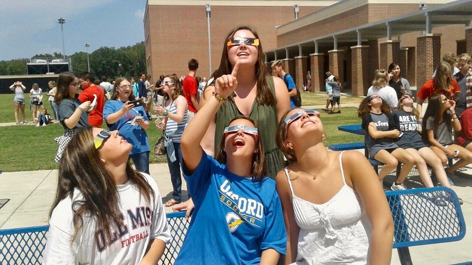 Juniors Kitty Case (left), Mary Gough (center), Katy Calderwood (right), and Campbell McCready (top) view the solar eclipse during 6th period. Many students had the opportunity to view the eclipse with glasses distributed by the Astronomy Club. 