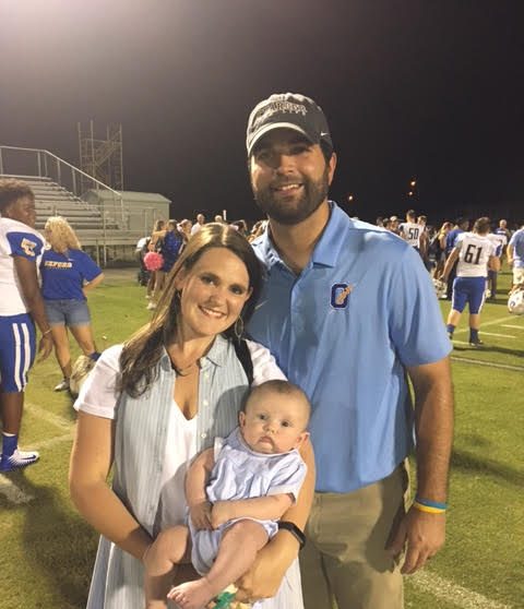 Logan Dodson poses with his wife, Kelsey, and son, William Still after a football game. Dodson recently got married and had a child. 