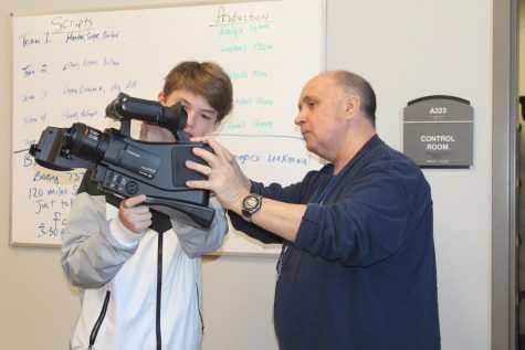 Broadcast Journalism teacher Keith Scruggs helps freshman Joel David Montgomery with one of the broadcast cameras. Scruggs has taught for six years, but this is his first year teaching at OHS.