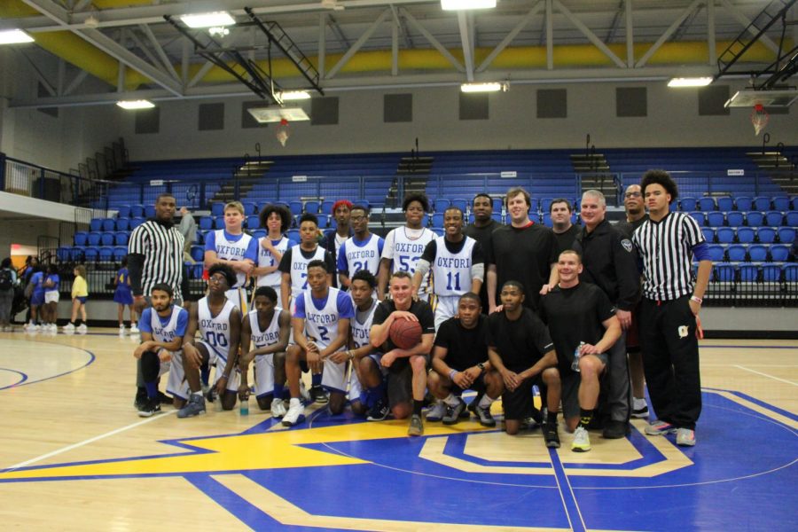 Unified Sports basketball team, Oxford Police Department officers, and the Unified Sports referees stand and smile after their game. The game resulted in a tie with a score of 40-40 after game tying threes were scored in the final seconds. 