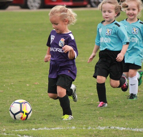 Three little girls run after the soccer ball during an OPC soccer game. Different OPC sports run throughout the whole year.