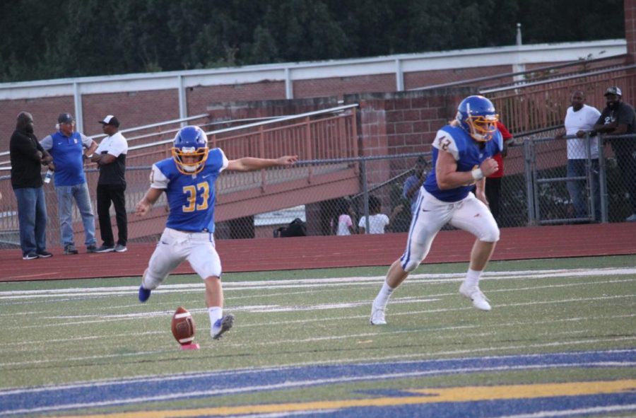 Junior Jack Tannehill kicks the ball off as Senior Clay Cromwell runs to cover the kick against Charleston. Cromwell scored the first touchdown of the 21-6 Charger win last Friday night.