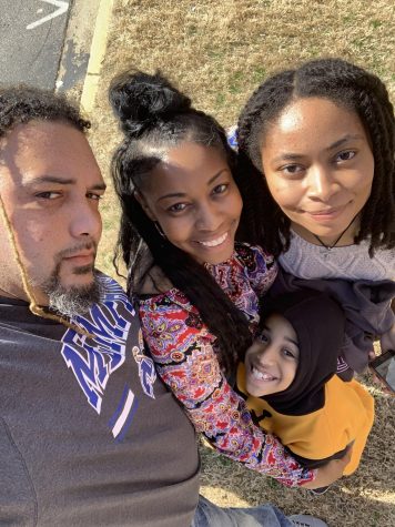 Art teacher Kevin Jones stands and smiles with his family in a selfie. Jones moved to Oxford this year in order to become the new art teacher.