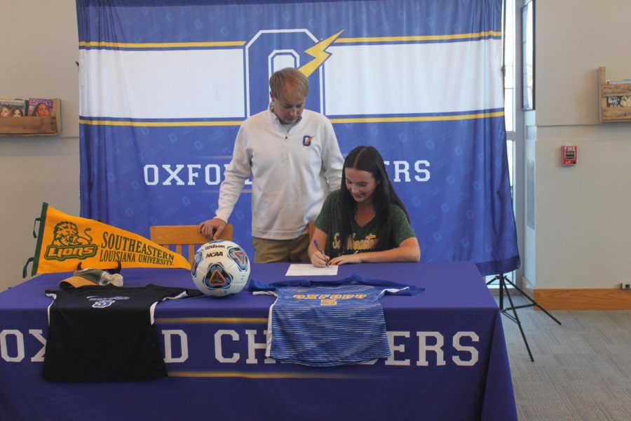 Senior Kathleen Myers signs her commitment to Southeastern Louisiana while her head soccer coach Hunter Crane watches. Myers had originally committed during her junior year.
