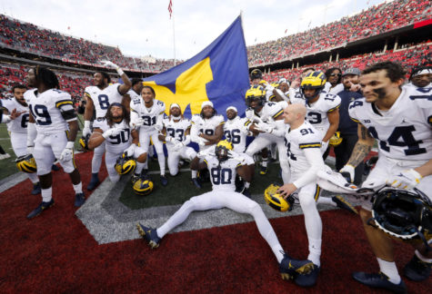 Nov 26, 2022; Columbus, Ohio, USA;  Michigan Wolverines players plant the flag on the Ohio State Buckeyes fifty yard line following the win at Ohio Stadium. Mandatory Credit: Joseph Maiorana-USA TODAY Sports